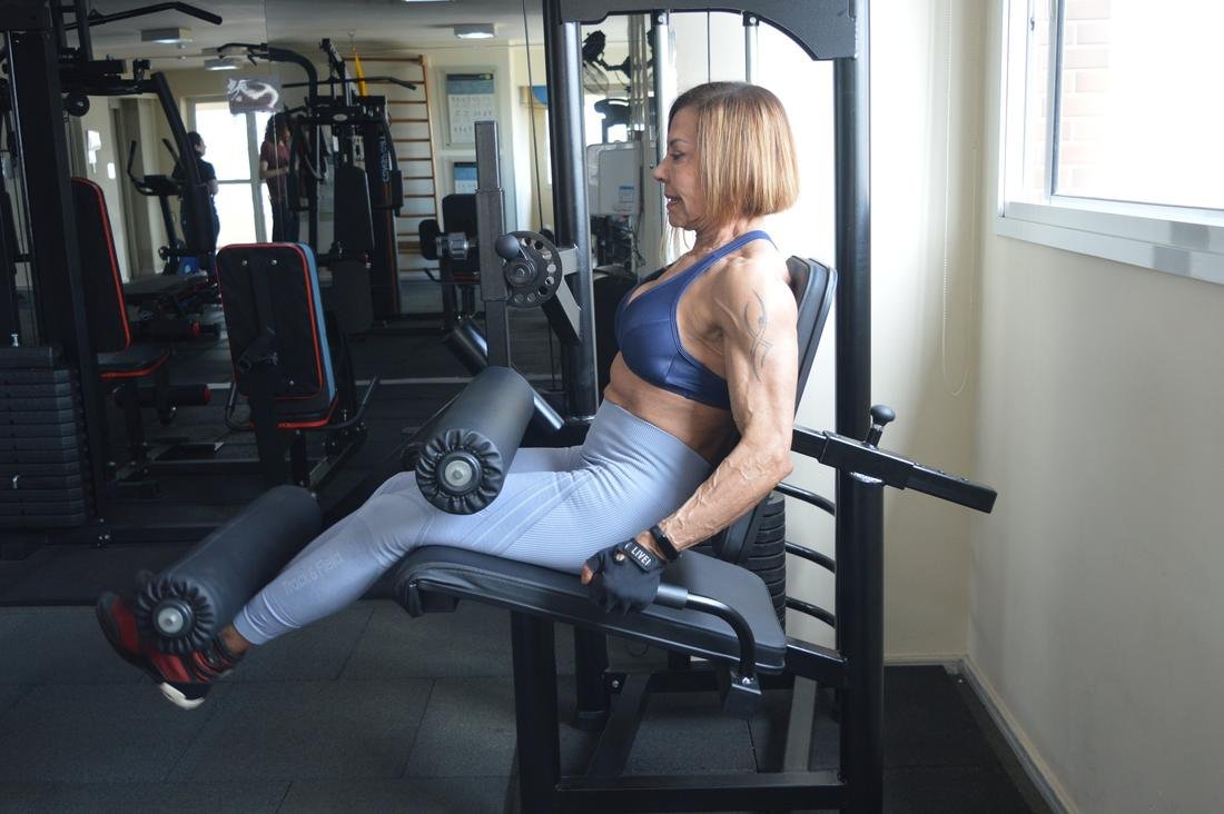 Silvia Masumoto treinando na cadeira extensora