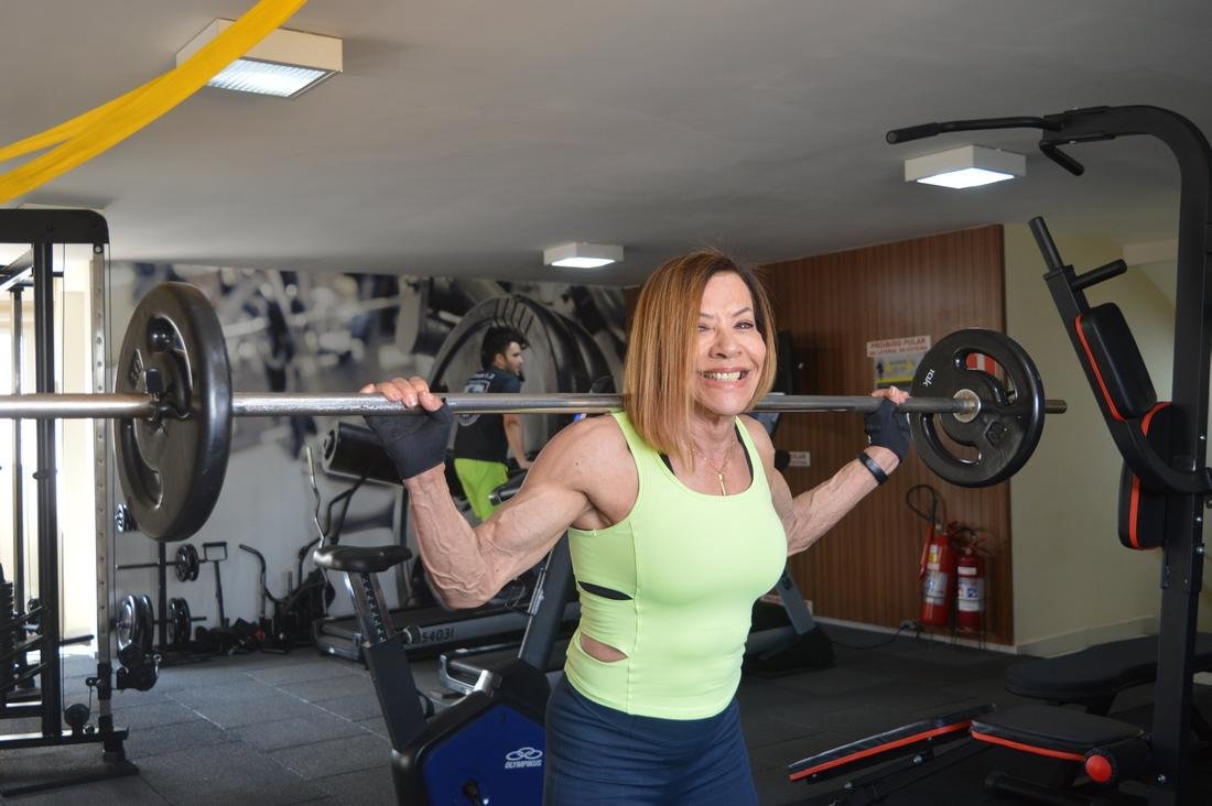 Silvia Masumoto sorrindo durante agachamento com barra
